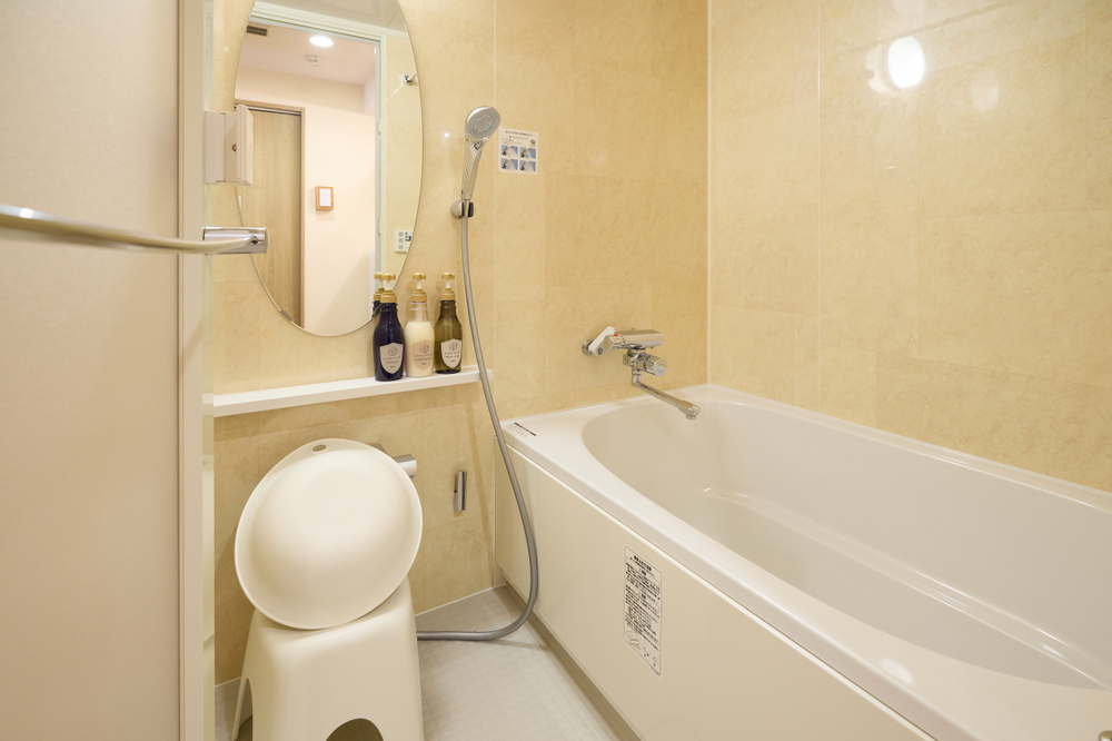 A casa de banho tem um estilo japonês e inclui um chuveiro, uma zona de lavagem e uma banheira. Esta está equipada com o popular chuveiro japonês "ReFa", que oferece 4 modos diferentes para uma experiência de banho luxuosa. Os chuveiros ReFa utilizam bolhas micro e ultrafinas para limpar a pele de forma delicada. Com quatro modos de jato de água e um design elegante, proporcionam uma experiência luxuosa, semelhante à de um spa, no conforto do seu apartamento.