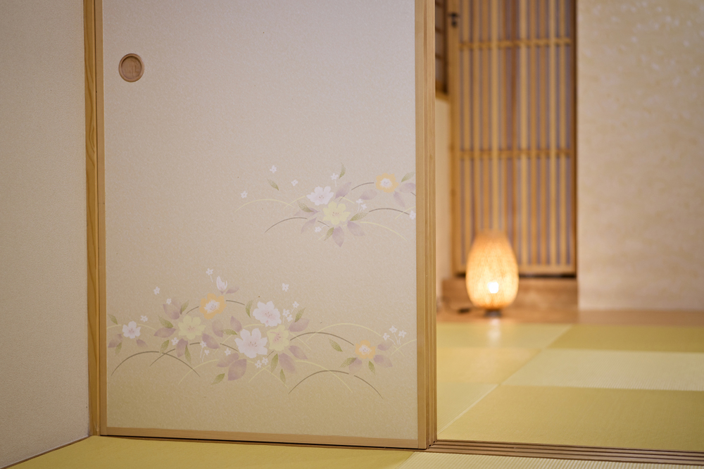 As portas de correr possuem delicadas ilustrações de flores de cerejeira, elegantemente pintadas em papel japonês fino washi.