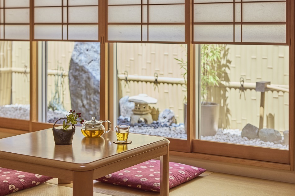 Da janela yukimi shoji do quarto com tatâmis, pode apreciar a vista para o jardim em pedra. As yukimi shoji são elegantes portas de correr tradicionais japonesas com um painel de vidro na parte inferior, concebidas para apreciar a vista para o exterior enquanto se está sentado.